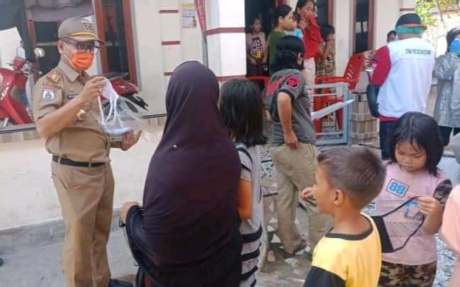 Kepala Dinas PTSP Andi Masri Masdar, Sos. M.Si nampak membagikan masker kepada warga Desa Tangnga-Tangnga, Kecamatan Tinambung (sumber foto : Fb. Info Publik Pemkab Polman) 